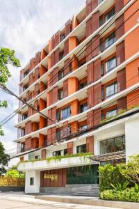 an orange and white apartment building at Tierra Residences Bangkok in Bangkok