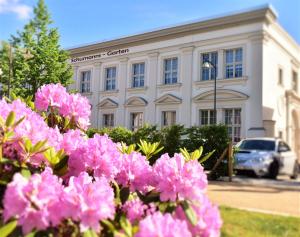 een gebouw met roze bloemen ervoor bij Schumanns Garten in Weißenfels