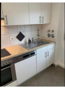 a kitchen with white cabinets and a sink at Monteurswohnung Albbruck in Albbruck