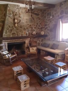 a living room with a couch and a fireplace at Valdolázaro in Los Navalucillos