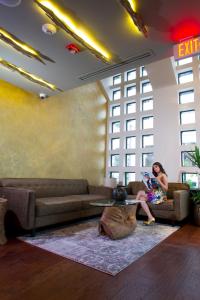 a woman sitting on a couch in a living room at Isabella Boutique Hotel in San Pedro Sula +41 photos