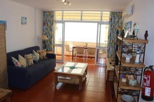 a living room with a blue couch and a table at Varandas SEA VIEW - Praia da Rocha in Portimão