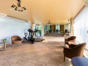 an indoor gym with chairs and a treadmill at OYO 750 Baan Suan Ampond in Bangkok