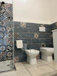 y baño con lavabo, aseo y azulejos. en Villa Harmony Retreat, en Budoni