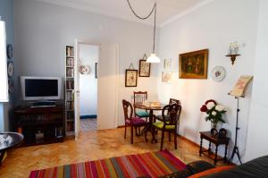 uma sala de estar com uma mesa e uma televisão em Casa do Jardim em Silves