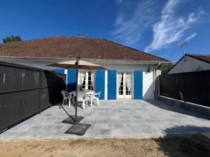 メルリモン・プラージュにあるLes Sylphides - Villa de charme à Merlimont-Plage - 4 personnesのパティオ(テーブル、傘付)