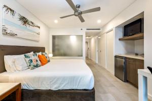 ein Schlafzimmer mit einem Bett und einem Deckenventilator in der Unterkunft Belle Escapes 228-229 Luxury Beachfront Resort Palm Cove in Palm Cove
