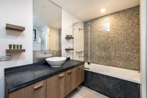 ein Badezimmer mit Waschbecken und Dusche in der Unterkunft Belle Escapes 228-229 Luxury Beachfront Resort Palm Cove in Palm Cove + 15 Fotos