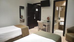 a hotel room with a bed and a desk and a bathroom at Hotel Moderno Puerta del Sol in Madrid