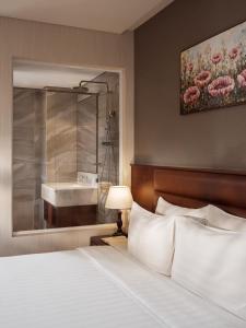 Postel nebo postele na pokoji v ubytování Orchids Saigon Hotel
