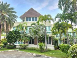 a house with palm trees in front of it at LELAWADEE Villa Cha -Am 