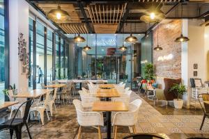 土格加劳Go Hotels Plus Tuguegarao的配有木桌和白色椅子的餐厅