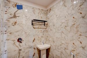a bathroom with a toilet and a marble wall at Hotel O Red Diamond Hotel in Ghaziabad