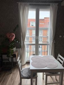 a dining room with a table and a large window at Centrum Apartament in Gdańsk