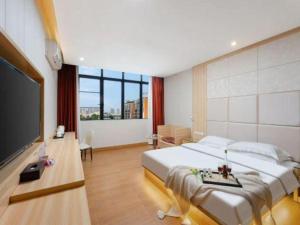 une chambre avec un grand lit et une télévision à écran plat dans l'établissement City Comfort Inn Yangjiang Baili Plaza Mojiang Road, à Yangjiang