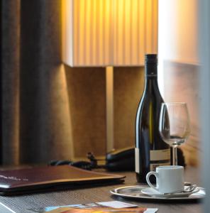 a bottle of wine sitting on a table with a glass at Hotel Lucia in Vienna