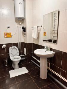 a bathroom with a toilet and a sink at Silk Way Hotel in Kokshetau