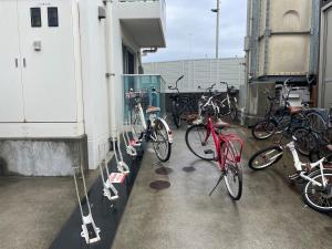 un gruppo di biciclette parcheggiate sul lato di un edificio di 301 湘南 鵠沼海岸 サーフィンに最適なビーチ近くの独立型アパート a Fujisawa
