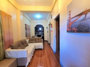 a living room with a white couch in a room at Jvc Zel transient house in Daraga