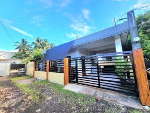 a house with a fence in front of it at Jvc Zel transient house in Locsin