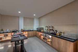 a large kitchen with wooden cabinets and a counter at SAZI RESIN HOTEL - Free Nails HairWash in Ho Chi Minh City