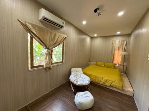 a small bedroom with a yellow bed and a window at The 47 House Homestay BMT in Buon Ma Thuot +142 photos