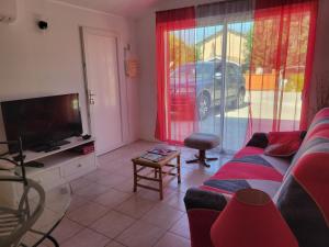 Una sala de estar con un sofá y un televisor. en Métairie de l'église, en Sainte-Marthe