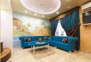a blue couch in a living room with a painting at Гостевой дом "Barkhat" in Izhevsk