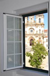 an open window with a view of a building at Hostel Rossio Alcobaça in Alcobaça