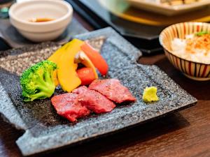 a plate of food with meat and vegetables on a table at Kirishima Momijidani Seiryuso - Vacation STAY 63072v in Kirishima