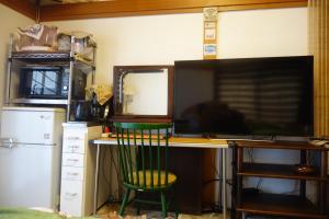 einen Schreibtisch mit einem Computermonitor und einem grünen Stuhl in der Unterkunft Natural Mind Tour - Vacation STAY 56703v in Sado + 13 Fotos