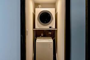 Zimmer mit einer Mikrowelle und einer Waschmaschine in der Unterkunft ann長良 in Gifu