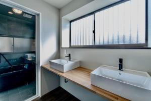 ein Badezimmer mit zwei Waschbecken und einem großen Fenster in der Unterkunft ann長良 in Gifu + 12 Fotos