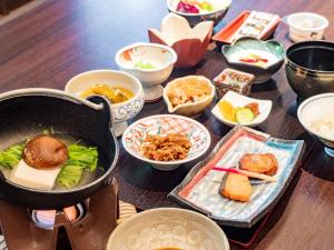 a table with a pan of food and bowls of food at Kirishima Momijidani Seiryuso - Vacation STAY 63066v in Kirishima +2 photos