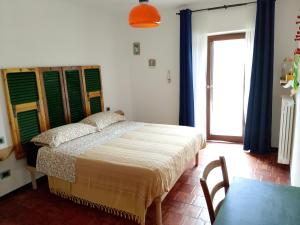 a bedroom with a bed and a table and a window at Ca du Sic in Merana