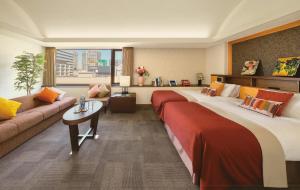 a hotel room with two beds and a couch at Shiba Park Hotel in Tokyo