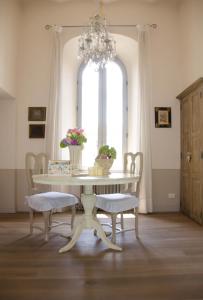 uma mesa de jantar com 2 cadeiras e um lustre em Palazzo Nicolai em Magione