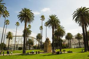 a park with palm trees and a building in the background at Cosy One Bedroom Apt Next to Park! in Melbourne