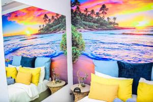 a room with a mural of the ocean and palm trees at TP Guesthouse in Phomolong