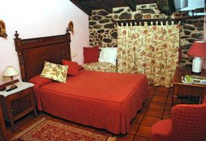 um quarto com uma cama com um edredão vermelho em Casa Rural Lazkaoetxe em Zaldivia