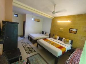 斋沙默尔Hotel Shahiraj Jaisalmer的有两张床和一张沙发的酒店房间