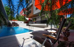 a swimming pool with two chairs and a table next to a building at Trend Suites in Antalya