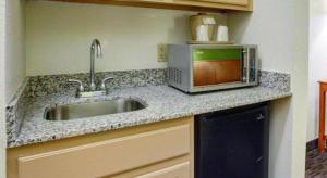 a kitchen counter with a sink and a microwave at Quality Inn & Suites Airport in Austin