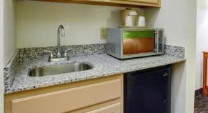 a kitchen counter with a sink and a microwave at Quality Inn & Suites Airport in Austin