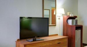 a flat screen tv sitting on top of a wooden dresser at Quality Inn & Suites Airport in Austin