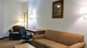 a living room with a couch and chairs in a hotel room at Quality Inn & Suites Airport in Austin
