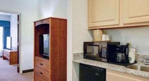 a kitchen with a sink and a microwave at Quality Inn & Suites Airport in Austin