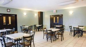 a restaurant with tables and chairs in a room at Quality Inn & Suites Airport in Austin