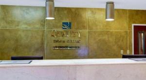 a waiting room with a counter and a sign on a wall at Quality Inn & Suites Airport in Austin