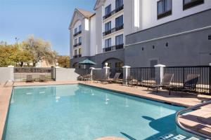 a swimming pool with chairs and a building at Hyatt Place Colorado Springs Garden Of The Gods in Colorado Springs